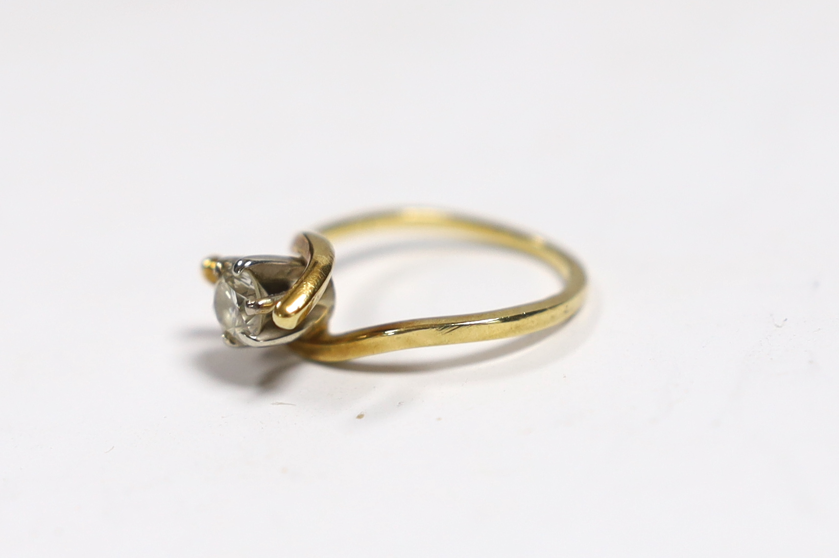 A yellow metal and solitaire diamond set ring, with crossover shoulders, size M, gross weight 3.5 grams.